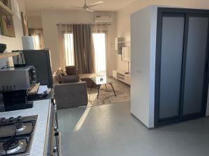 a kitchen with a living room with a stove at Rubis2 appart C2 in Ngaparou