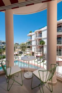 a balcony with two chairs and a table and chairs at Villa Coo Boutique Hotel - Adults Only in Kos