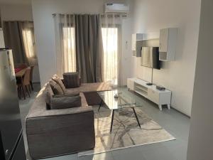 a living room with a couch and a glass table at Rubis2 appart C2 in Ngaparou