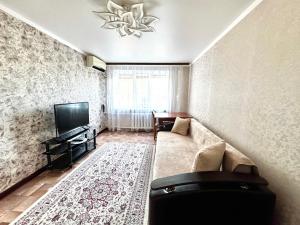 a living room with a couch and a television at Квартира 2х ком на Амангельды 1 in Balqash