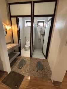 a bathroom with a shower and a toilet and a sink at Lơ Mơ House in Làng Môn