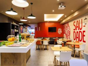a restaurant with tables and chairs and a bar at Hotel ibis Lisboa Liberdade in Lisbon