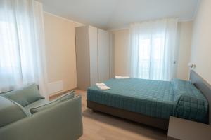 a small bedroom with a bed and a couch at Residence La Scogliera in Alassio