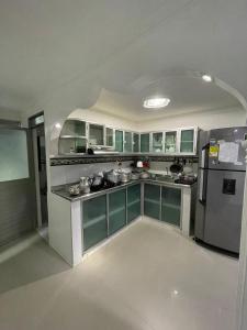a kitchen with green and white cabinets and a refrigerator at Habitaciones Melany in Coveñas