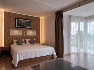 a bedroom with a bed and a large window at Viešbutis Banga in Tauragė +36 photos