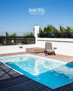 a chair sitting on a deck next to a swimming pool at Bella Vista Hotel - Encarnación in Encarnación