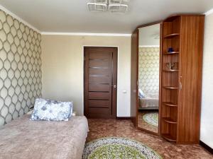 a bedroom with a bed and a large mirror at Квартира 2х ком на Амангельды 1 in Balqash