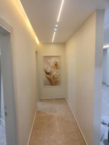 a hallway with a painting of flowers on the wall at Your sweet house in Minshāt Şabrī