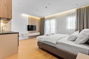 a bedroom with a large bed and a kitchen at VELIERO Residence by Bracera in Lugovi