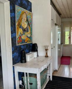 a painting of a woman on the wall in a kitchen at Suvela in Muurame