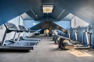 a gym with a row of treadmills and machines at Cotswolds Apartment 3 Sleeps 9 in Chipping Norton