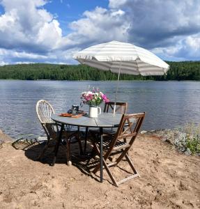 a table with two chairs and an umbrella on the beach at Suvela in Muurame