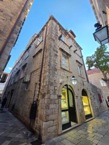 an old brick building with a door on a street at Lausa Dubrovnik Rooms in Dubrovnik