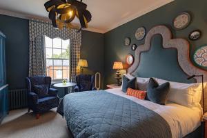 a bedroom with a bed and chairs and a window at Ansty Hall in Coventry +93 photos