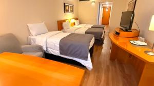 a hotel room with two beds and a flat screen tv at Hotel & Residence Alphaville in Barueri +22 photos