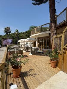 a wooden deck with potted plants and a tree at Sènia Botànic Bonavista in Calella