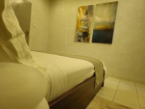 a bedroom with a bed with a mirror and a painting at Domaine Béthania in Tadiénou