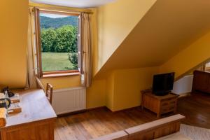 a living room with yellow walls and a window at Karczma Regionalna Hotel GOŚCINNA CHATA in Wysowa-Zdrój