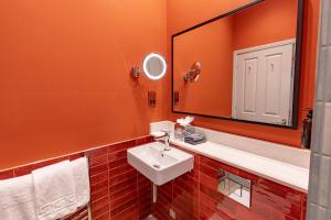 a bathroom with a sink and a large mirror at Ansty Hall in Coventry