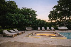 a patio with lounge chairs and a fire pit at Finca Hotel Dubai in San Jerónimo