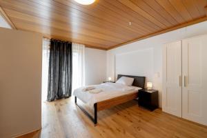 a bedroom with a bed and a large window at Boardinghaus Perani in Augsburg