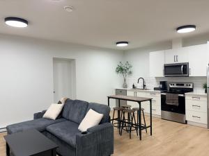 a living room with a couch and a kitchen at Upscale One Bedroom Suite in New Build in Kelowna