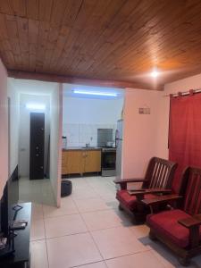 a living room with two chairs and a kitchen at René Favaloro in Rincon de los Sauces