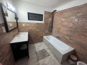 a bathroom with a bath tub and a sink at René Favaloro in Rincon de los Sauces