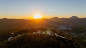 an aerial view of the sun setting over a city at Refúgio Tapera Bungalows & Wellness in Venda Nova do Imigrante +28 photos