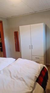 a bedroom with a bed and a white cabinet at Sentral leilighet Odda Trolltunga in Odda