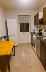 a kitchen with a wooden table and a kitchen with a window at Sentral leilighet Odda Trolltunga in Odda +3 photos