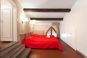 czerwone łóżko z czerwonym kocem w pokoju w obiekcie Riverside Apartment in Florence we Florencji