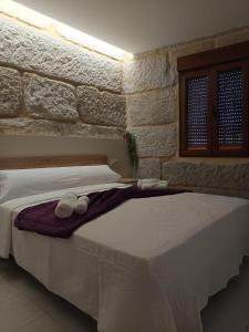 a bedroom with a large bed with towels on it at Casa Pampillon in Cangas de Morrazo