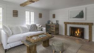 a living room with a white couch and a fireplace at The Inn at GrayBarns in Norwalk