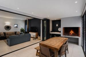 a living room with a table and a fireplace at Above Board in Yzerfontein