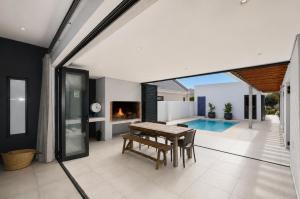 a dining room with a table and a fireplace at Above Board in Yzerfontein