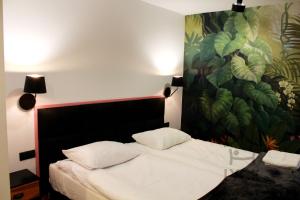 a bedroom with a bed with a painting on the wall at Lyck Aparthotel in Ełk