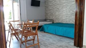 a room with two chairs and a table and a bed at Muretto House in Oreoi