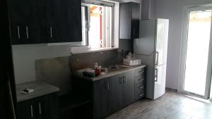a kitchen with black cabinets and a sink and a window at Muretto House in Oreoi +8 photos