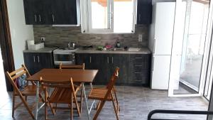 a kitchen with a table and chairs and a sink at Muretto House in Oreoi