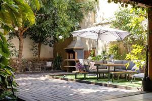 an outdoor seating area with a table and an umbrella at Portrait Boutique Villa in Valencia
