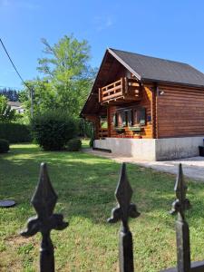 a wooden house with a fence in front of it at Holiday Home Geppetto in Gornji Velemerić
