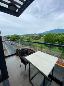a white table and chair on a balcony with a view at REVU 519 in Tepic