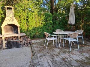 a table and chairs and an umbrella and a fireplace at Holiday Home Geppetto in Gornji Velemerić +9 photos