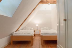 two beds in a room with a attic at Ferienwohnung Blücherkate II - Boldevitzer Rügenkaten in Parchtitz +2 photos