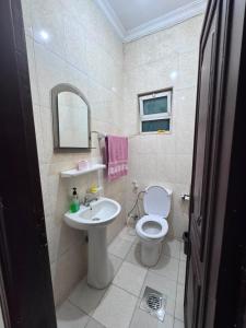 a bathroom with a white toilet and a sink at شقه مفروشة الجبيهه in Amman +63 photos