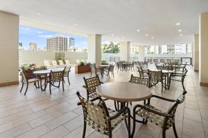 a restaurant with tables and chairs and a view of the city at Royal Kuhio Resort in Honolulu