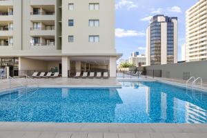 a swimming pool in front of a building at Royal Kuhio Resort in Honolulu