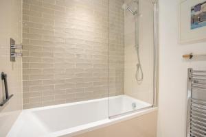 a bathroom with a tub and a glass shower at 2 Bed in Porthcawl oc-87294 in Porthcawl +23 photos