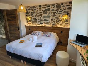 a bedroom with a bed with a stone wall at Maison Serrioux in Cholonge